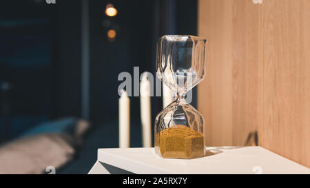 Sand running through the bulbs of an hourglass. Hourglass as time passing concept for business deadline Stock Photo