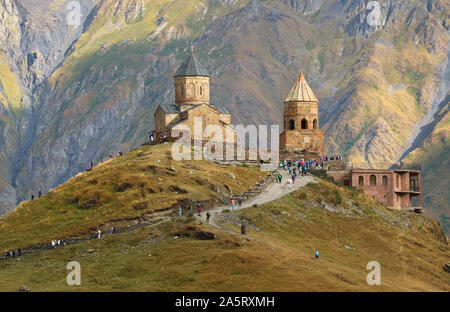 Large group of people visiting the famous Gergeti Trinity Church in Stepantsminda town, Kazbegi, Georgia Country Stock Photo