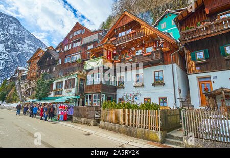 HALLSTATT, AUSTRIA - FEBRUARY 21, 2019: The tourists at the souvenir stalls of the small market, situated in Seestrasse street of old town, on Februar Stock Photo