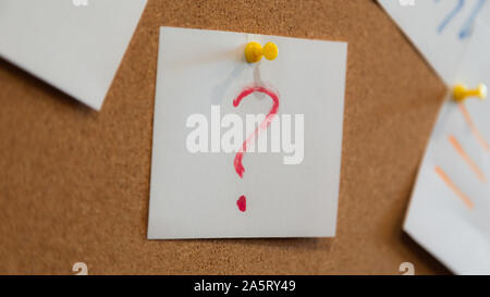 Red question mark on a piece of paper and many papers. Question concept. Stock Photo
