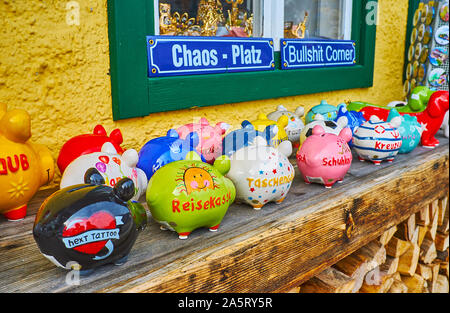 HALLSTATT, AUSTRIA - FEBRUARY 21, 2019: The souvenir store offers many different piggy banks, decorated with colorful pictures and signs, on February Stock Photo
