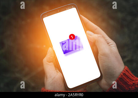 Woman hand using a smartphone and receives many letters. Creative concept with paper envelope and unread letters icon on smartphone screen Stock Photo