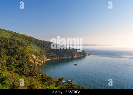 View from the top of mountains of Buyukada island, one of the Princess Islands, Adalar, Marmara Sea, Istanbul, Turkey, with green woods, calm sea, and clear sky at sunset time Stock Photo