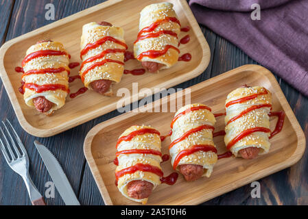 Sausage rolls on the wooden tray: top view