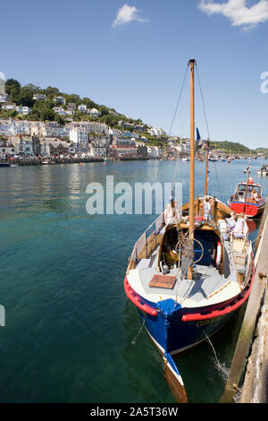 Looe Harbour, Cornwall, with West Looe across the water and the old lifeboat 'Clovelly' moored in the foreground, and now used for trips round the bay Stock Photo