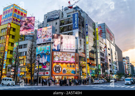 Tokyo, Akihabara, Crossroads on the main shopping street, Chuo Dori. People waiting at zebra crossing to cross street. Stores and cafes background. Stock Photo