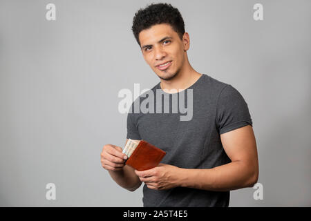 Hispanic man smiling in studio with gray background Stock Photo