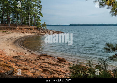 Severe drought conditions at Lake Lanier, Georgia eroding the shoreline exposing the rocks and boulders on a sunny day in fall Stock Photo