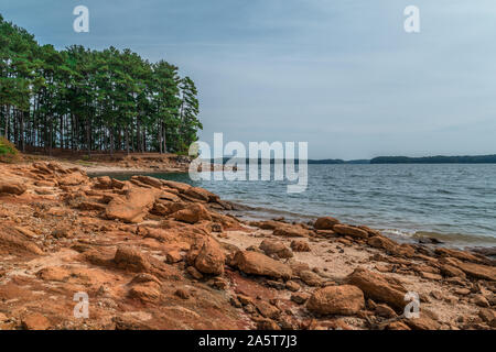 Severe drought conditions at Lake Lanier, Georgia eroding the shoreline exposing the rocks and boulders on a sunny day in fall Stock Photo