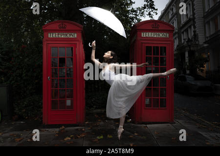 London, UK. 22nd Oct, 2019. World Ballet Day: Rebecca Olarescu, a student at the Royal Academy of Dance (RAD), performs in the early evening light near two red phone booths in the streets of north west London. Credit: Guy Corbishley/Alamy Live News Stock Photo