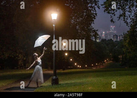 London, UK. 22nd Oct, 2019. World Ballet Day: Rebecca Olarescu, a student at the Royal Academy of Dance (RAD), strikes a pose near the illuminated lamp rows of Primrose Hill in north west London. Credit: Guy Corbishley/Alamy Live News Stock Photo