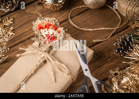 Preparations of the  christmas gifts. Hand crafted DIY gift box and Christmas ornaments desktop scene. Natural present boxes for Christmas, New year o Stock Photo