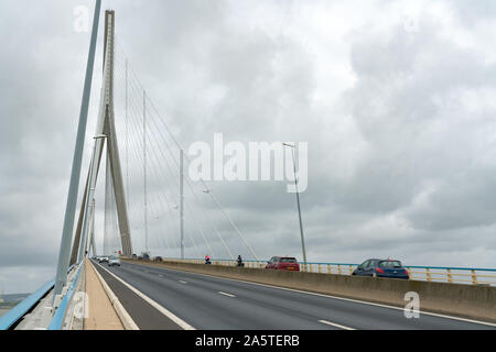 Honfleur, Calvados / France - 15 August 2019: cyclists and holiday traffic crossing the Normandy Bridge between Le Havre and Honfleur Stock Photo
