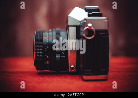 old camera with lens on wooden table. He took a picture of a lot of great and memorable moments Stock Photo