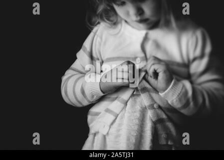 toddler learning to button sweater Stock Photo