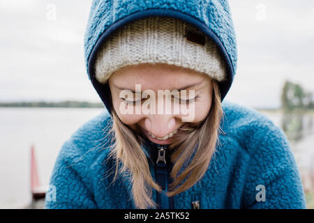 close up portrait of woman looking down laughing whilst camping Stock Photo