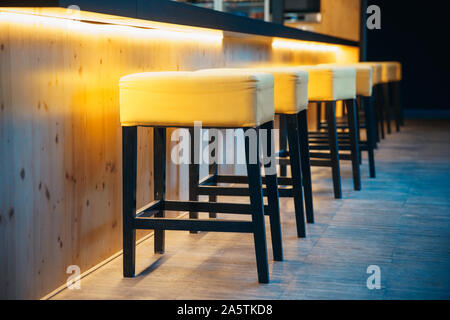 barstools at the counter in a night bar for sitting of visitors Stock Photo