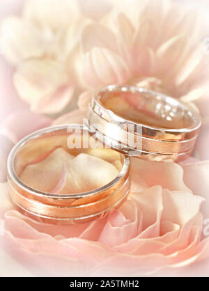 Closeup of wedding rings on background of  flowers. Studio, macro shoot. Engagement conceptual picture. Stock Photo