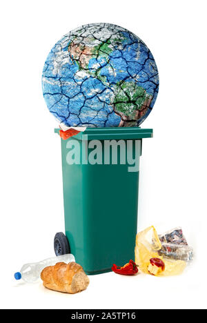 Conceptual image of planet destroying. Planet Earth is thrown into garbage, discarded food, waste,trash,  isolated on a white background. Conceptual Stock Photo