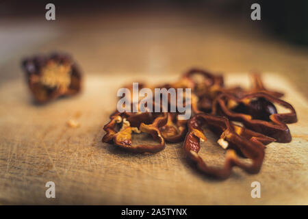 Chocolate Habanero pepper (Capsicum chinense) slices on a wood cutting board. Healthy and really hot chili peppers. Stock Photo