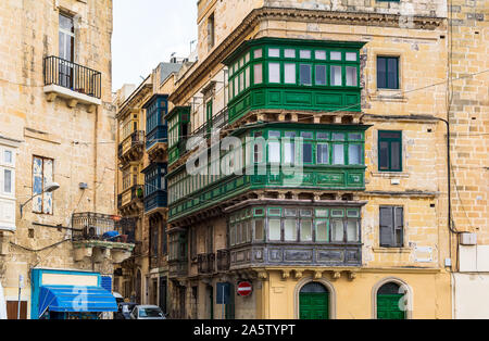 Residential house facade with traditional Maltese multicolored enclosed wooden balconies in Valletta, Malta, in summer day. Stock Photo