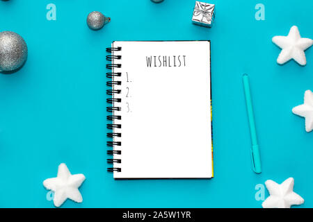 Notebook with wish list on mint green background. Top view. Stock Photo