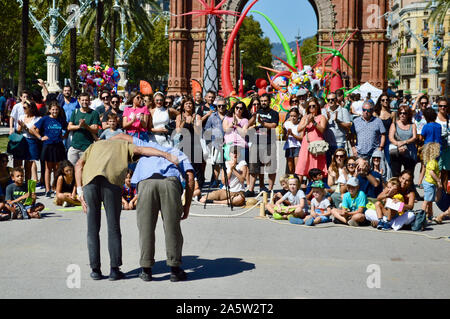 People watching a performance by two men at Ciutadella Park during La Merce 2019 in Barcelona, Spain Stock Photo