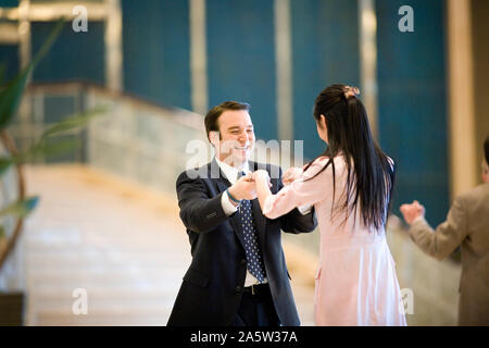 Young adult couple dancing in a hotel lobby. Stock Photo