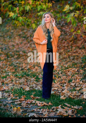 Cozy outfit ideas for weekend. Woman walk sunset light. Clothing for every  day. Cozy casual outfits for fall. Girl adorable blonde posing in warm and  cozy outfit autumn nature background defocused Stock