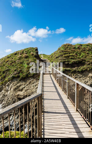 The footbridge linking the mainland to Porth Island Trevelgue Head at Newquay in Cornwall. Stock Photo