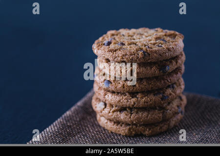 Stacked oatmeal handmade chocolate cookies on black slate plate isolated Stock Photo
