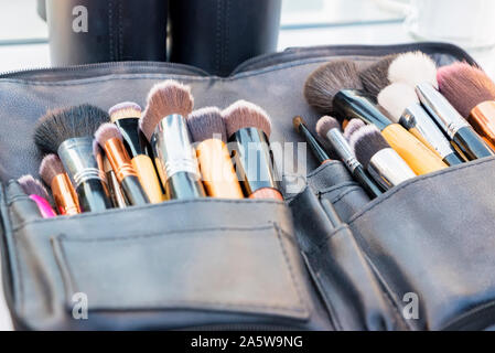 Close up various professional make up brushes lying in dark case Stock Photo