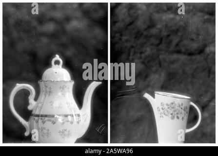 Diptych of two ceramic jars. Black and white medium format negative film, scratched during development. Soft focus lens. Lava rock background wall. Stock Photo