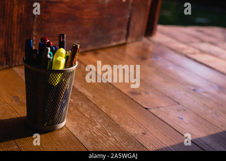 Pencil box full of pencil and scissors on the wooden floor. Stock Photo