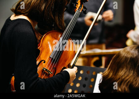 Woman fiddler during a concert, background in black. Stock Photo