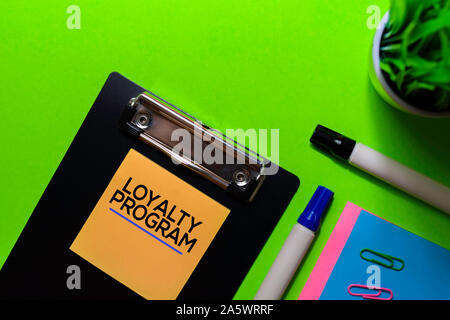 Loyalty Program write on sticky notes. Isolated on green table background Stock Photo