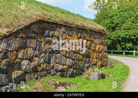 Old stone wall with orange colour lichen on Suomenlinna fortress island in Helsinki Finland Stock Photo