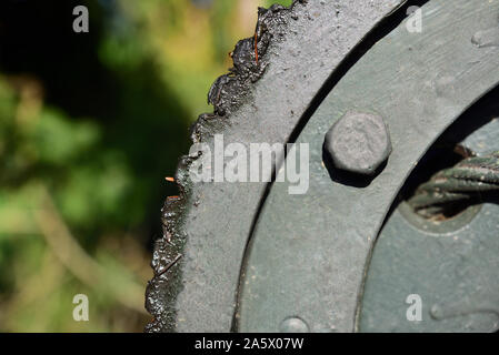 Detail of a gear of iron, which is part of a winch, with greased gears, in nature outside Stock Photo
