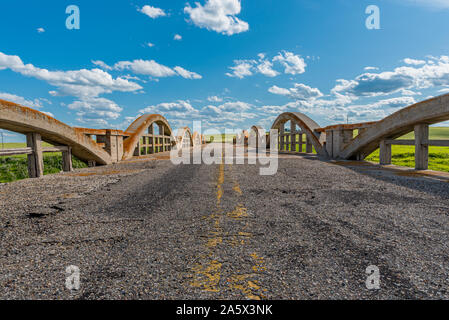 Road leading nowhere over historic concrete bridge in Scotsguard, SK Stock Photo