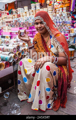 A portrait of a woman working in a market selling bangles and drinking chai, Jodhpur, Rajasthan, India. Stock Photo