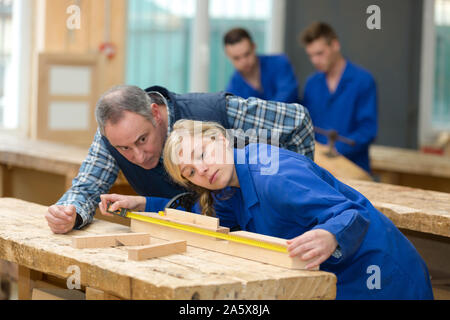master is helping woman to working with wood Stock Photo