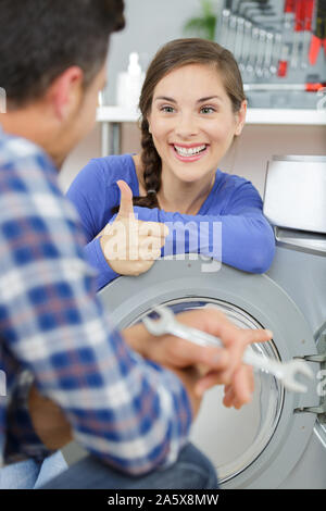 repairman repairing washing machine at home Stock Photo
