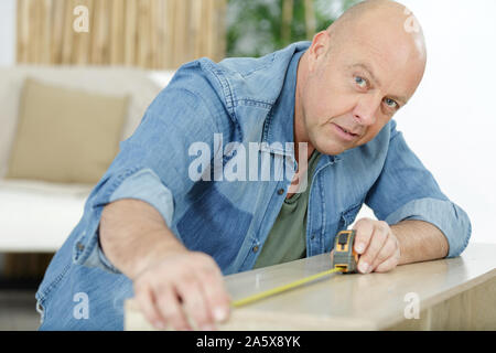 male carpenter uses measuring tape measure wood Stock Photo