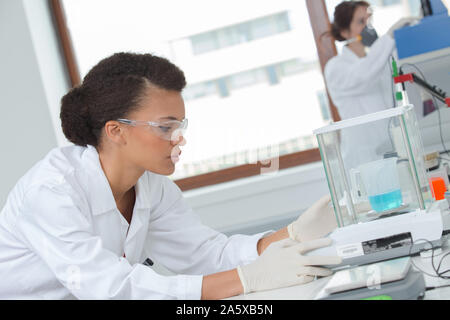 female lab worker look for chemical data in laboratory Stock Photo