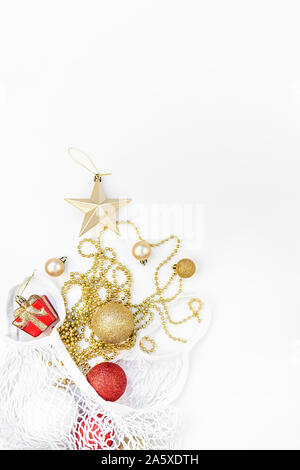 Christmas composition. New Year or Christmas flat lay top view Xmas holiday decorative golden toys in eco-friendly shopping mesh bag on white backgrou Stock Photo