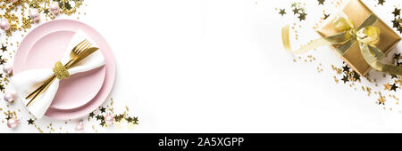 Christmas banner. Table setting with golden dishware, party decorations on white background. Top view. Xmas dinner. Stock Photo