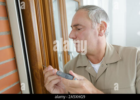 installation of furniture hinges on the cabinet door Stock Photo
