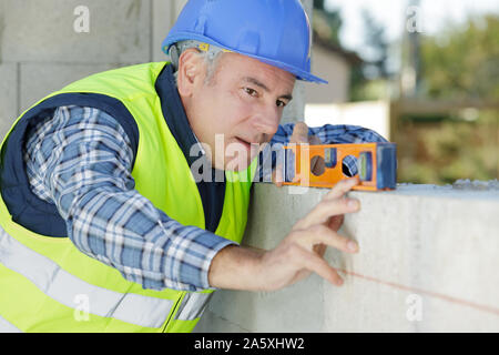 man measuring plane using a spirit level Stock Photo