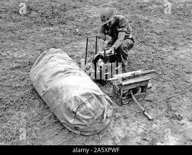 Fifth Army. Anzio Area, Italy. Dummy tank designed by British, made of rubber and inflated when used. Can be assembled in 20 minutes. When used in field can simulate tank positions. Dummy rubber tank used by British, in carrying Bag. Body and turret are separate pieces but are contained in this bag together. In the right background can be seen an Italian generator which is used to inflate the body assembly, and in the right foreground is seen the standard British Army Engineer Issue Gorge Pump which is used to inflate the turret. Stock Photo