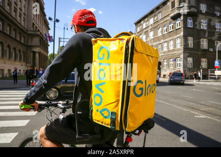 Zagreb, Croatia - October 20, 2019. Rear view of a worker with big yellow bag from Glovo, home delivery company for food and drink on the streets of Z Stock Photo